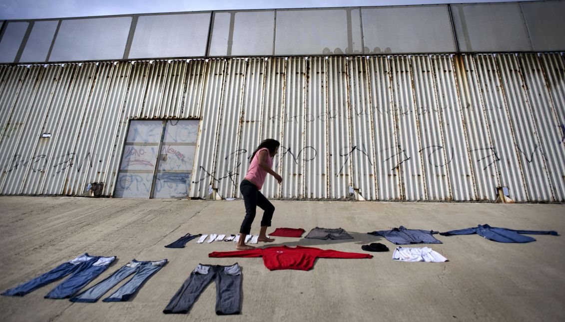 Marta Sandoval, 36, lays out clothing to dry in front of the US-Mexico border wall on the bank of the Tijuana River canal, which has become home to hundreds of people deported from the US, in Tijuana, Mexico, 03 May 2013. EPA-EFE FILE/DAVID MAUNG