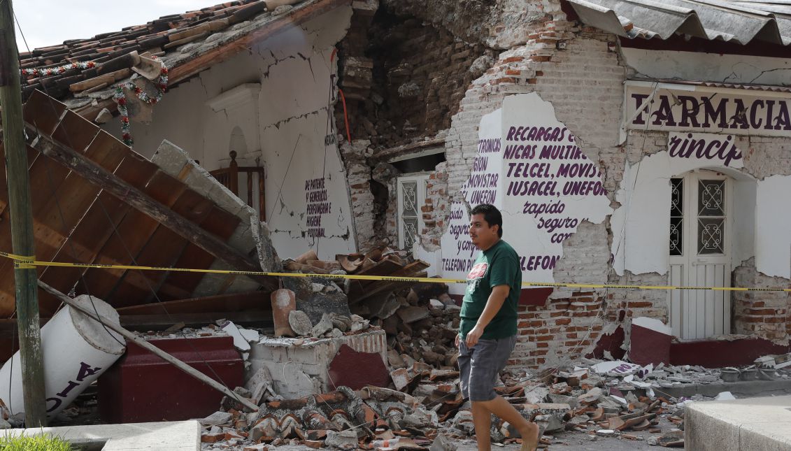 People walk next to buildings affected by the earthquake, in the town of Ixtaltepec, Oaxaca, Mexico on Sept. 10, 2017. EPA-EFE/Jorge Nunez
