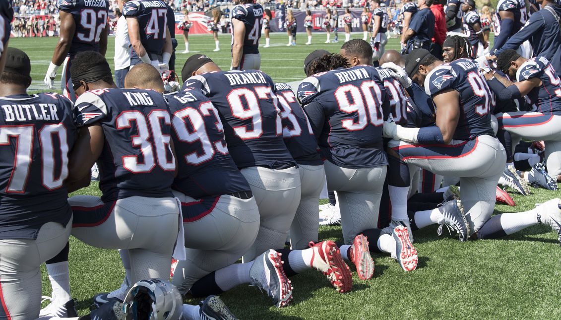 New England Patriots players hold hands and kneel during the National Anthem prior to the start of their game against the Houston Texans at Gillette Stadium in Foxboro, Massachusetts, USA, 24 September 2017. EPA-EFE/JOHN CETRINO
