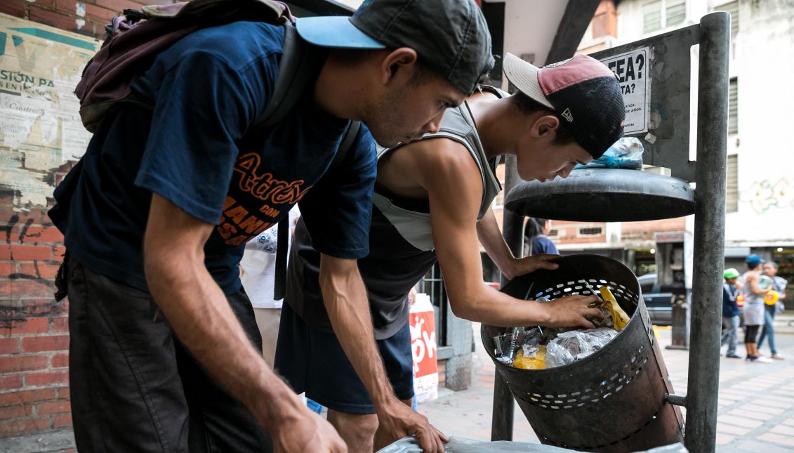 Two men rummaging through trash cans for something edible, in Caracas, Venezuela on Sept. 20, 2017. EPA-EFE/Miguel Gutierrez
