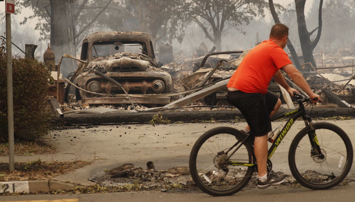 A resident rides past a burnt out home in Santa Rosa, California, USA, 09 October 2017. EPA-EFE/JOHN G. MABANGLO