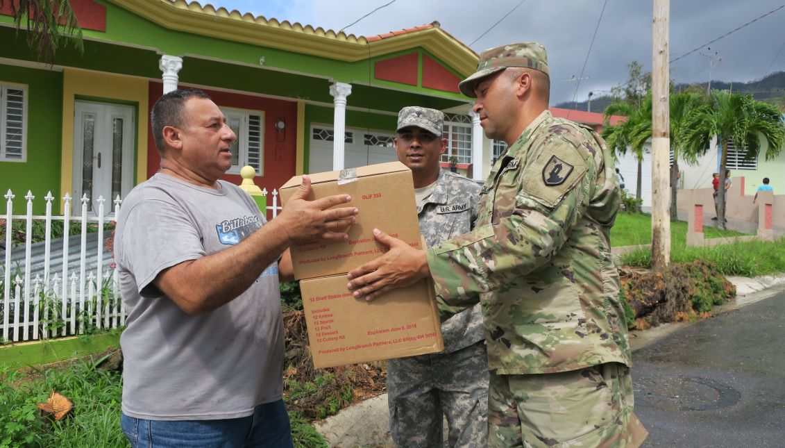 Officers of the National Guard of Puerto Rico deliver boxes with food to a inhabitant, in Jayuya, Puerto Rico, Oct. 11, 2017. EPA-EFE/JORGE MUÑIZ
