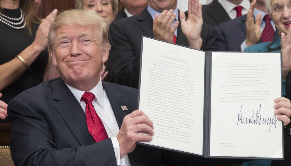 US President Donald J. Trump holds up an executive order on healthcare after signing it during a ceremony in the Roosevelt Room of the White House in Washington, DC, USA, Oct. 12, 2017. EPA-EFE/MICHAEL REYNOLDS