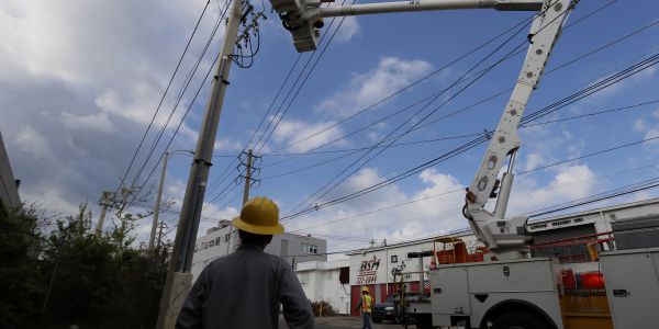 Employees of the state-owned utility AEE doing repairing works in San Juan, Puerto Rico on Oct. 6, 2017. EPA-EFE FILE/Thais Llorca
