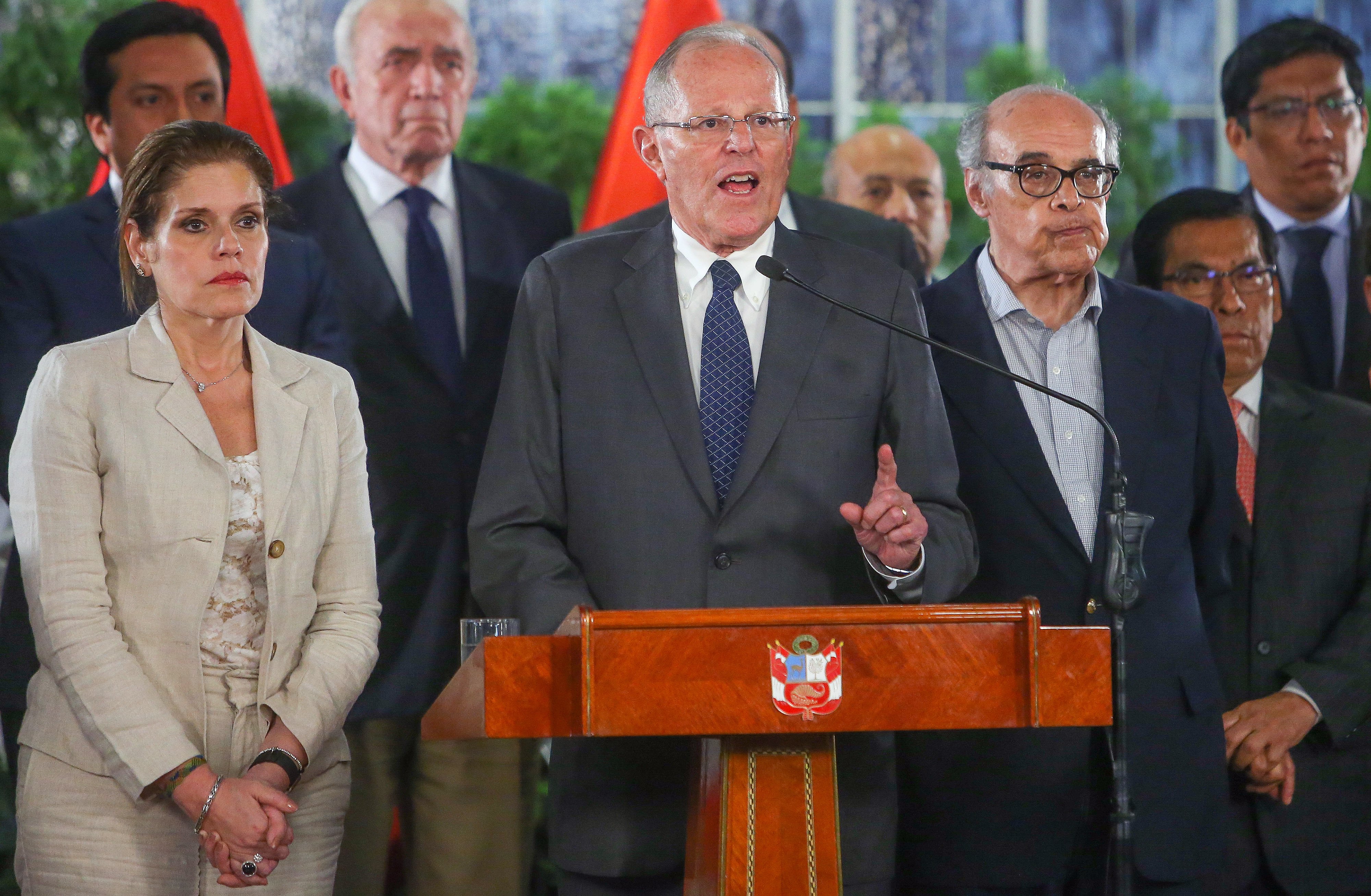 A handout photo made available by the Press of the Presidency of Peru shows the President of Peru Pedro Pablo Kuczynski (C) speaking while accompanied by Prime Minister Mercedes Araoz (L) and the Chancellor Ricardo Luna (2-R), during a message to the nation, in the Government Palace in Lima, Peru, Dec. 14, 2017.