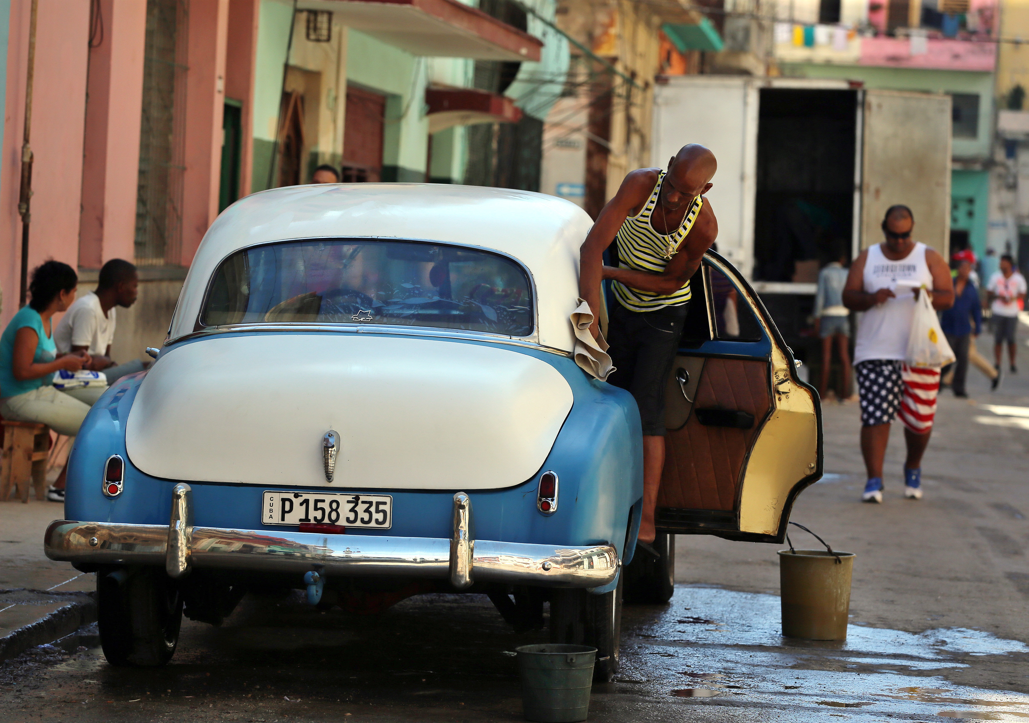 A man cleans an old US car in Havana, Cuba, on Dec. 17, 2017.
