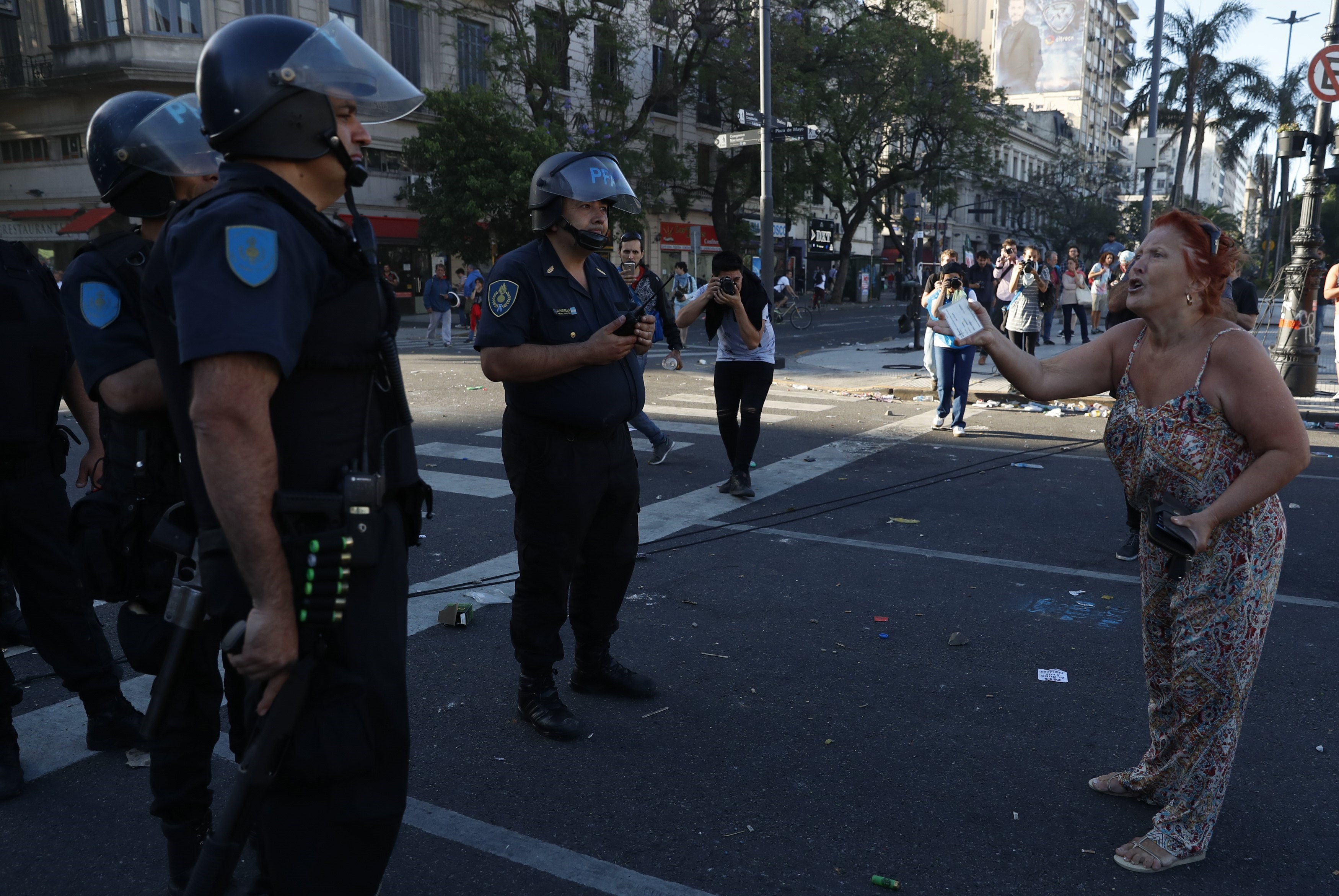 A woman shouts in front of members the Argentinean Federal Police, in Buenos Aires, Argentina, Dec. 18, 2017.