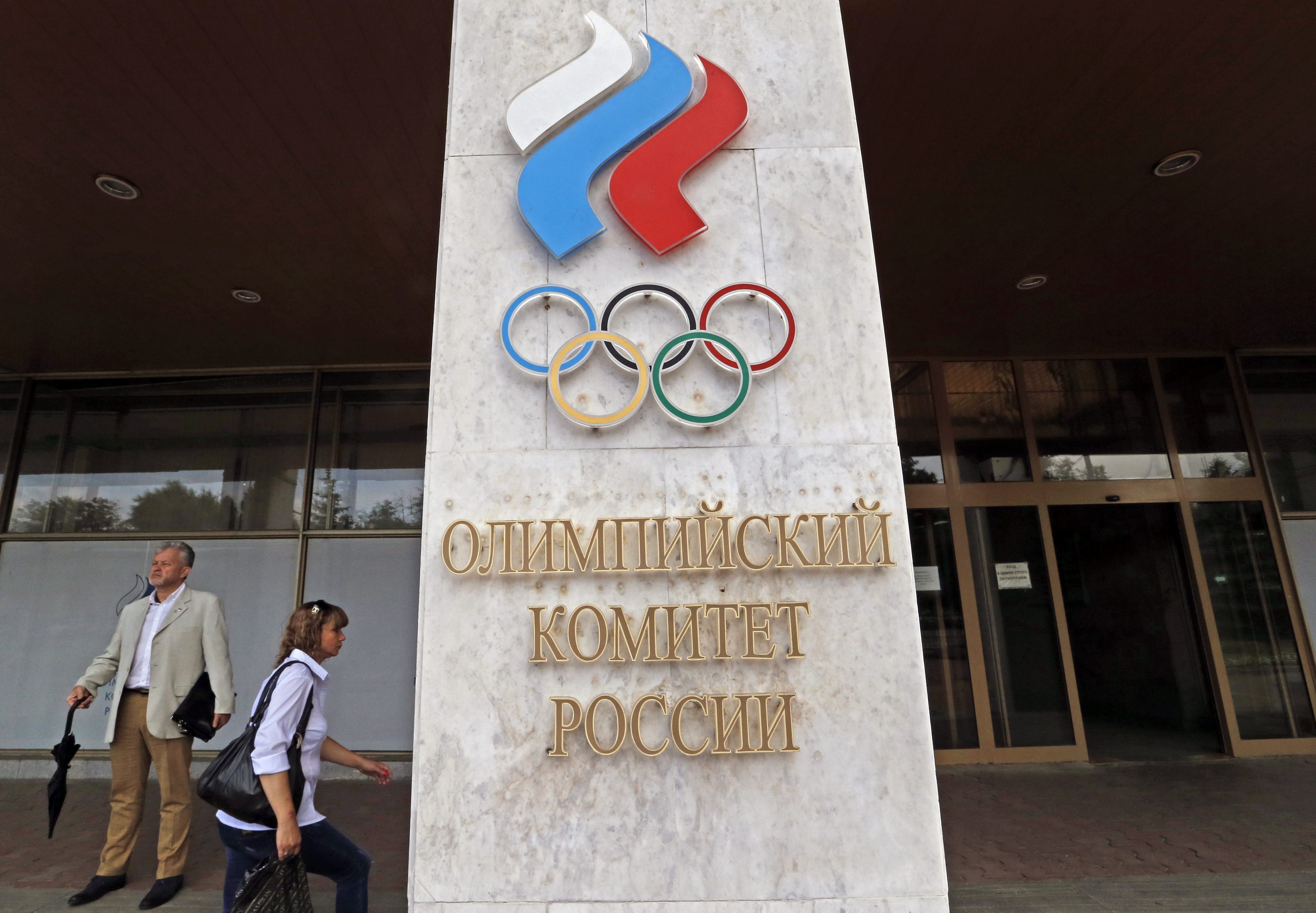 People walk in front of the Russian Olympic Committee headquarters and Russian Athletics Federation office in Moscow, Russia, July 19, 2016.
