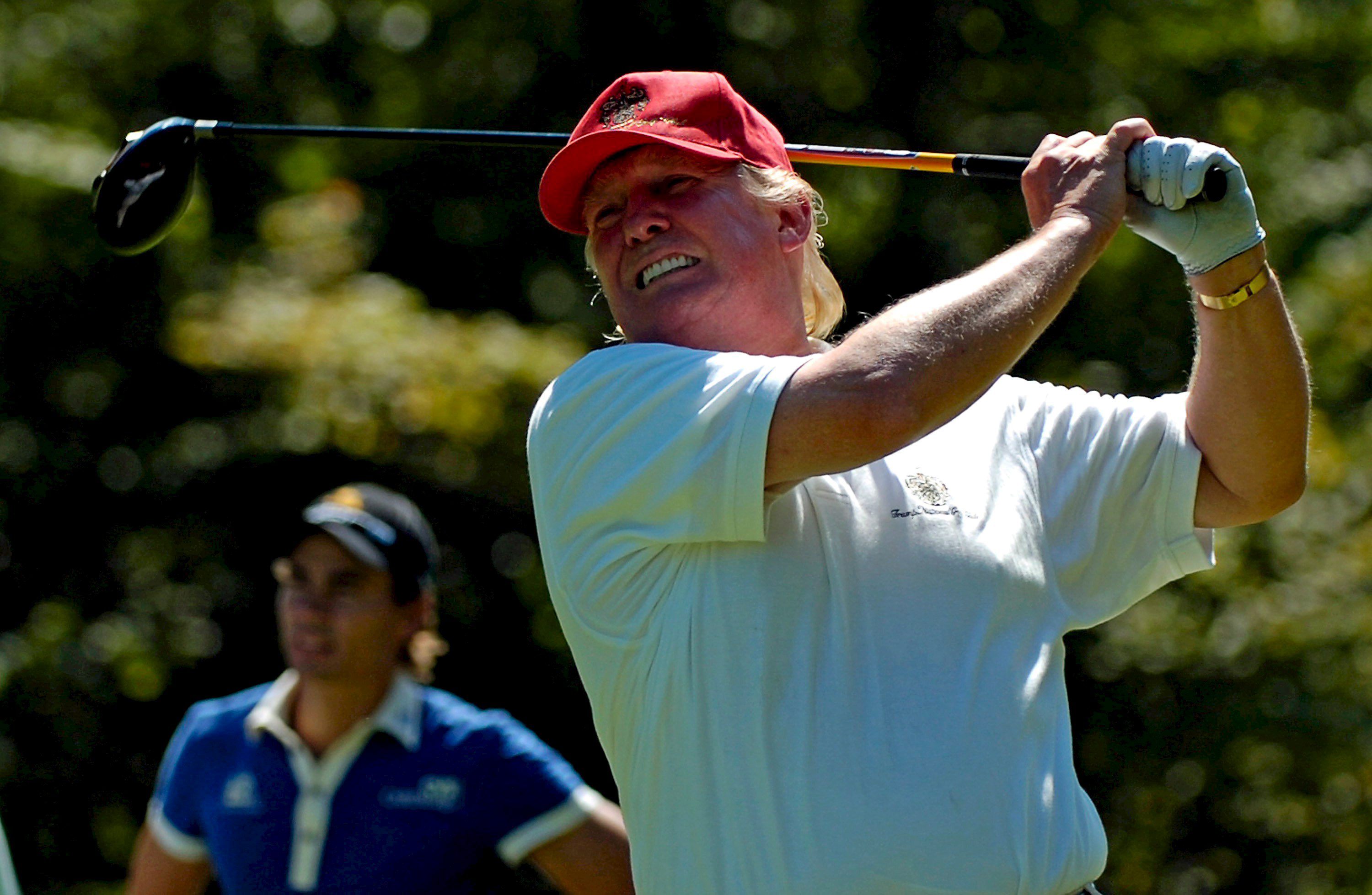 Real Estate Mogul Donald Trump tees off at the second tee as Camilo Villegas of Columbia (L) looks on during the ProAm round of the Deutsche Bank tournament held at the Tournament Players Club Boston in Norton Massachusetts, USA on Aug. 30, 2007.
