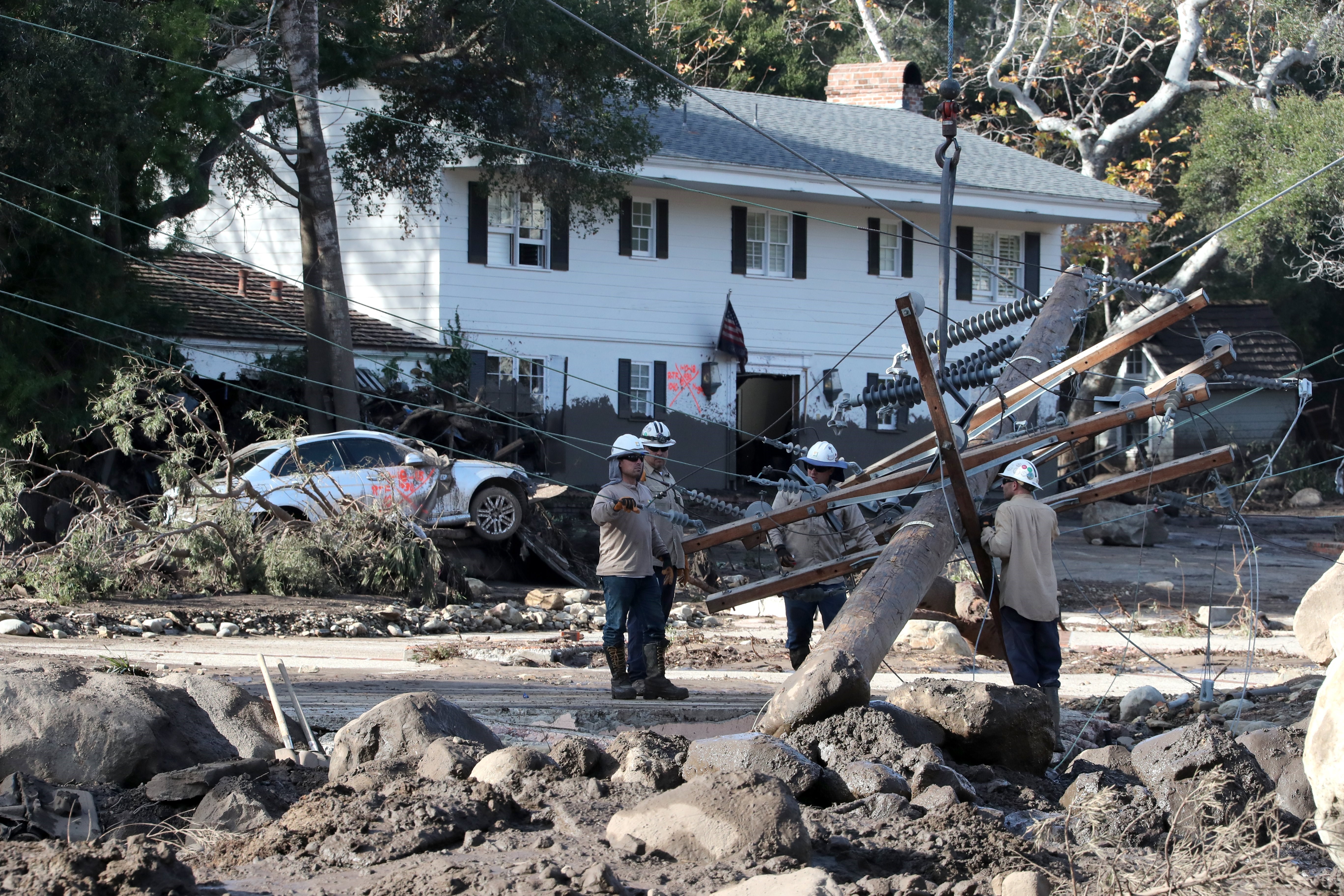 A handout photo made available by the Santa Barbara County Fire department shows Kerry Mann navigate the large boulders and mudflow that destroyed the home of her friend who has not been seen since the early hours of 09 January following heavy rains in Montecito, California, USA, 10 January 2018.
