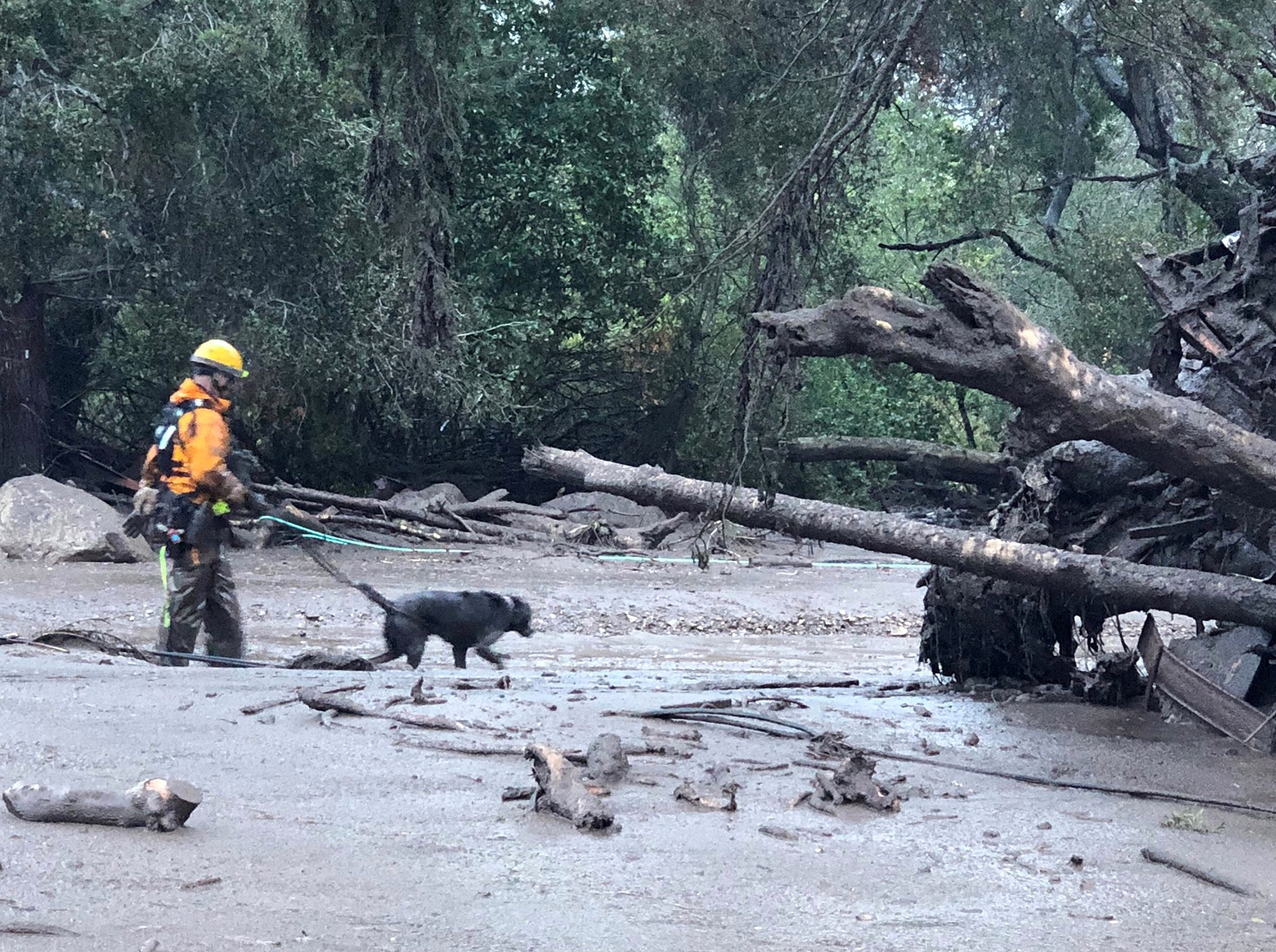 Firefighters work on rescue and recovery tasks during intense rain in Montecito, California, where flooding and landslides have killed at least 20 people, as of Jan. 14, 2018.