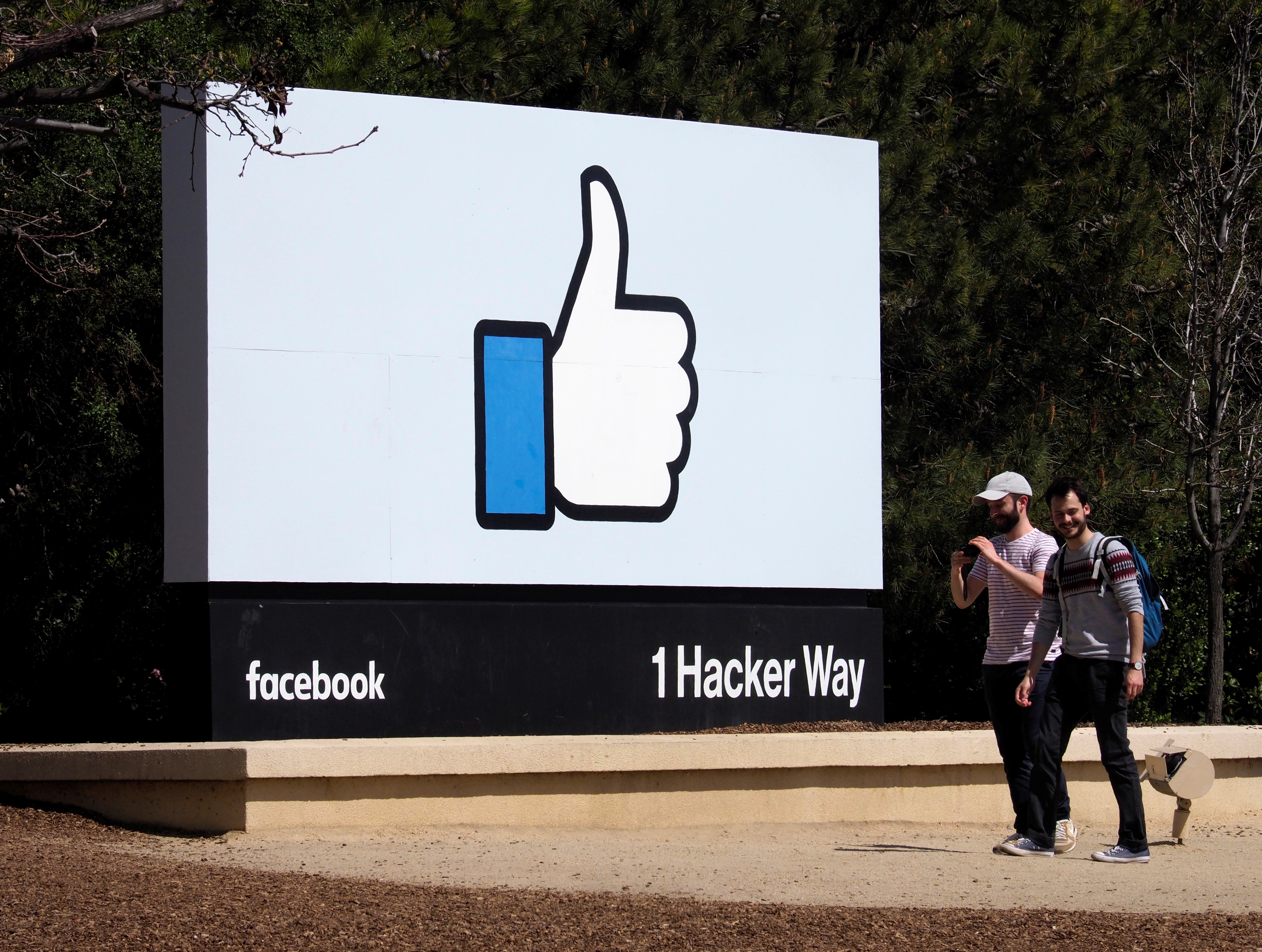 People walk past Facebook's 'Like' icon signage in front of their campus building in Menlo Park, California, Mar. 30, 2018. EPA-EFE/FILE/JOHN G. MABANGLO