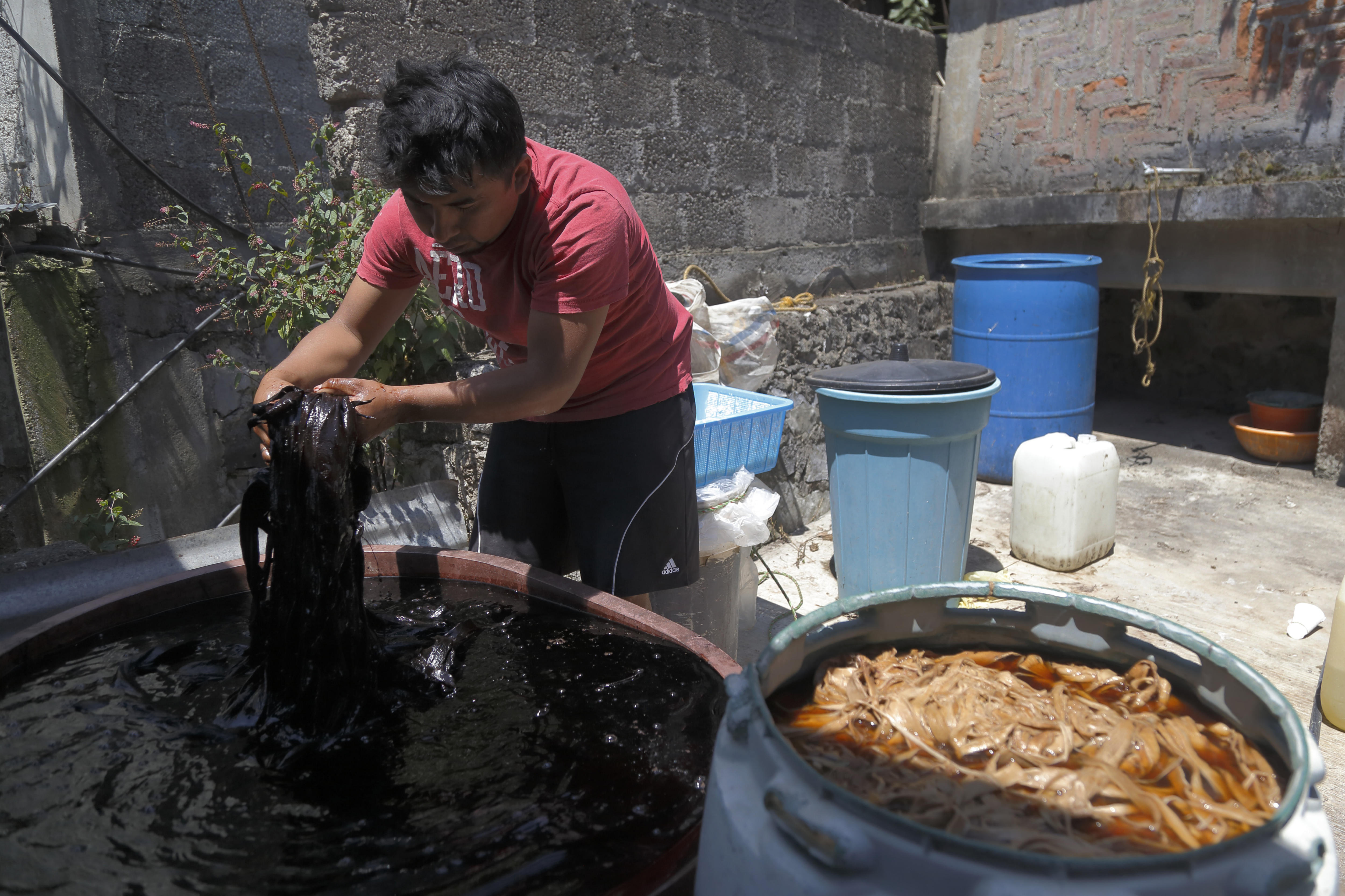 Photograph provided May 6, 2018, showing Jose Luis Santos boiling pieces of jonote tree bark, the raw material of amate paper in San Pablito, Mexico, Apr. 18, 2018. EPA-EFE/Francisco Guasco