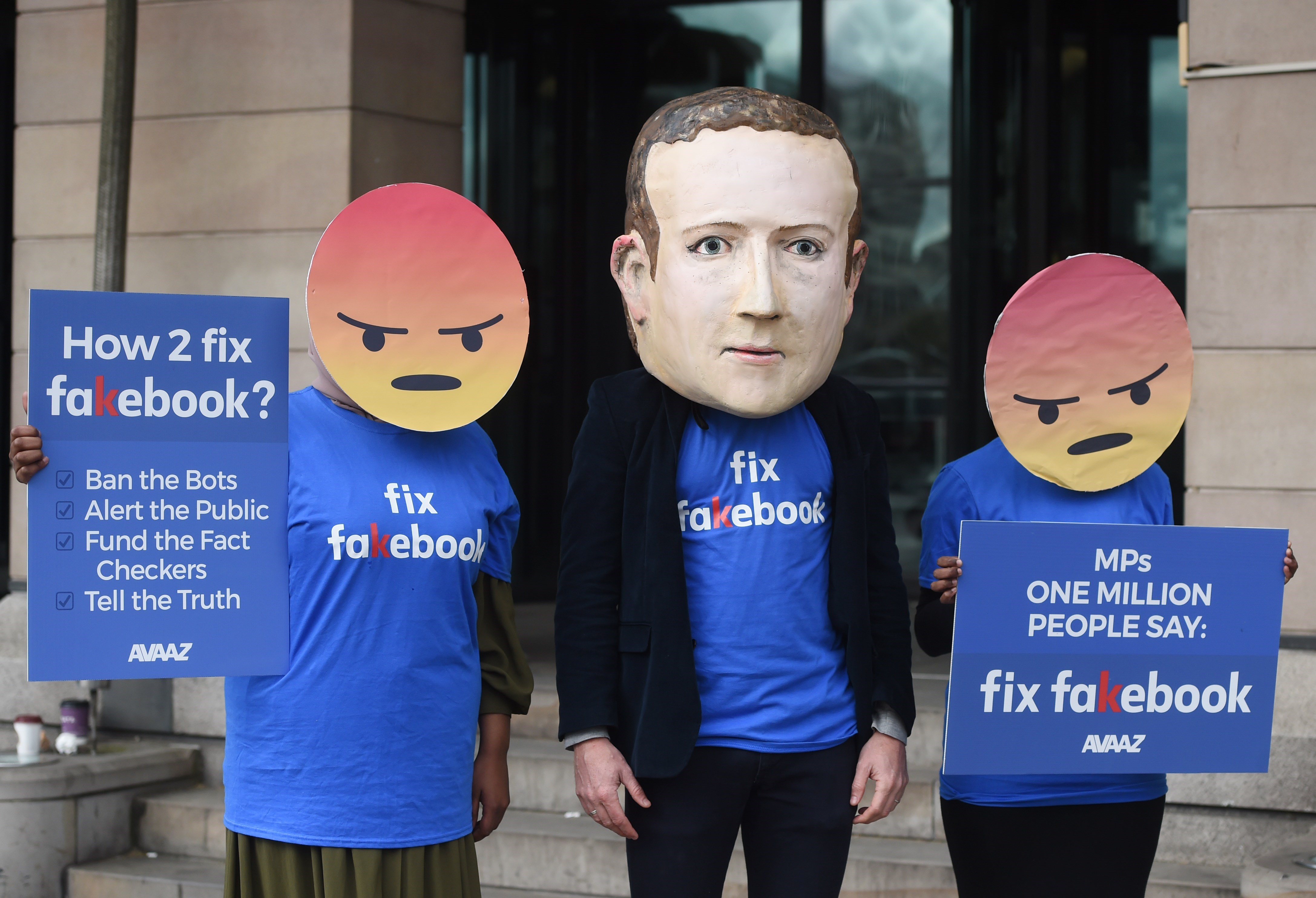 A protester wearing a mask depicting Facebook's CEO, Mark Zuckerberg, flanked by two protesters wearing angry emoji masks protest outside Portcullis House in central London, Britain, Apr 26, 2018. after allegations that information on millions of its users was misused. EPA-EFE (FILE) /FACUNDO ARRIZABALAGA
