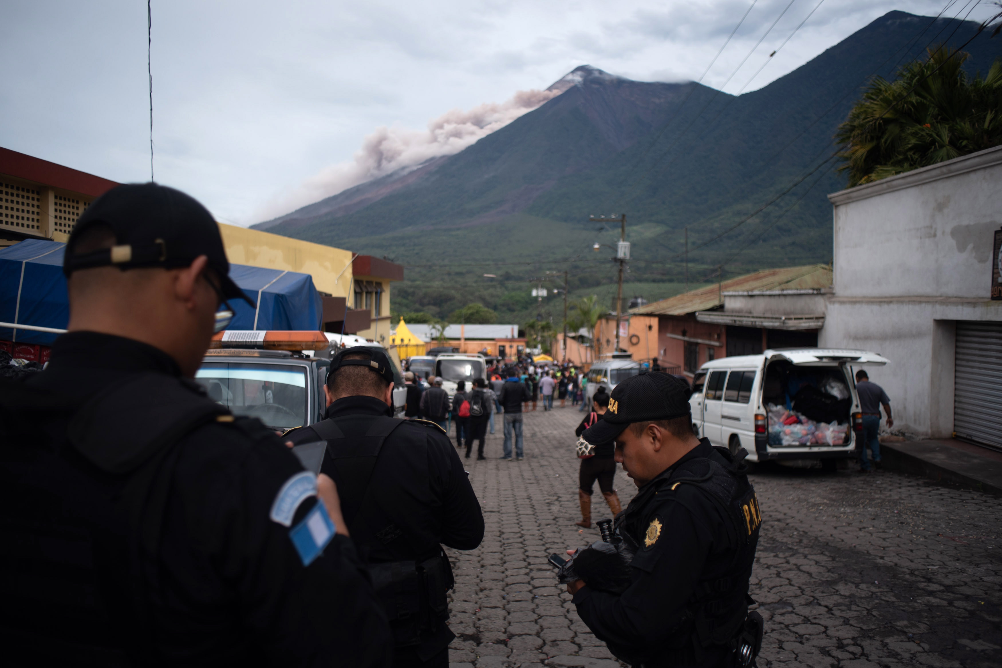 Members of the Guatemalan National Civil Police watch Fuego volcano as it produces a lahar seen from Alotenango, Sacatepequez, Guatemala, June 8, 2018. EPA-EFE/Santiago Billy