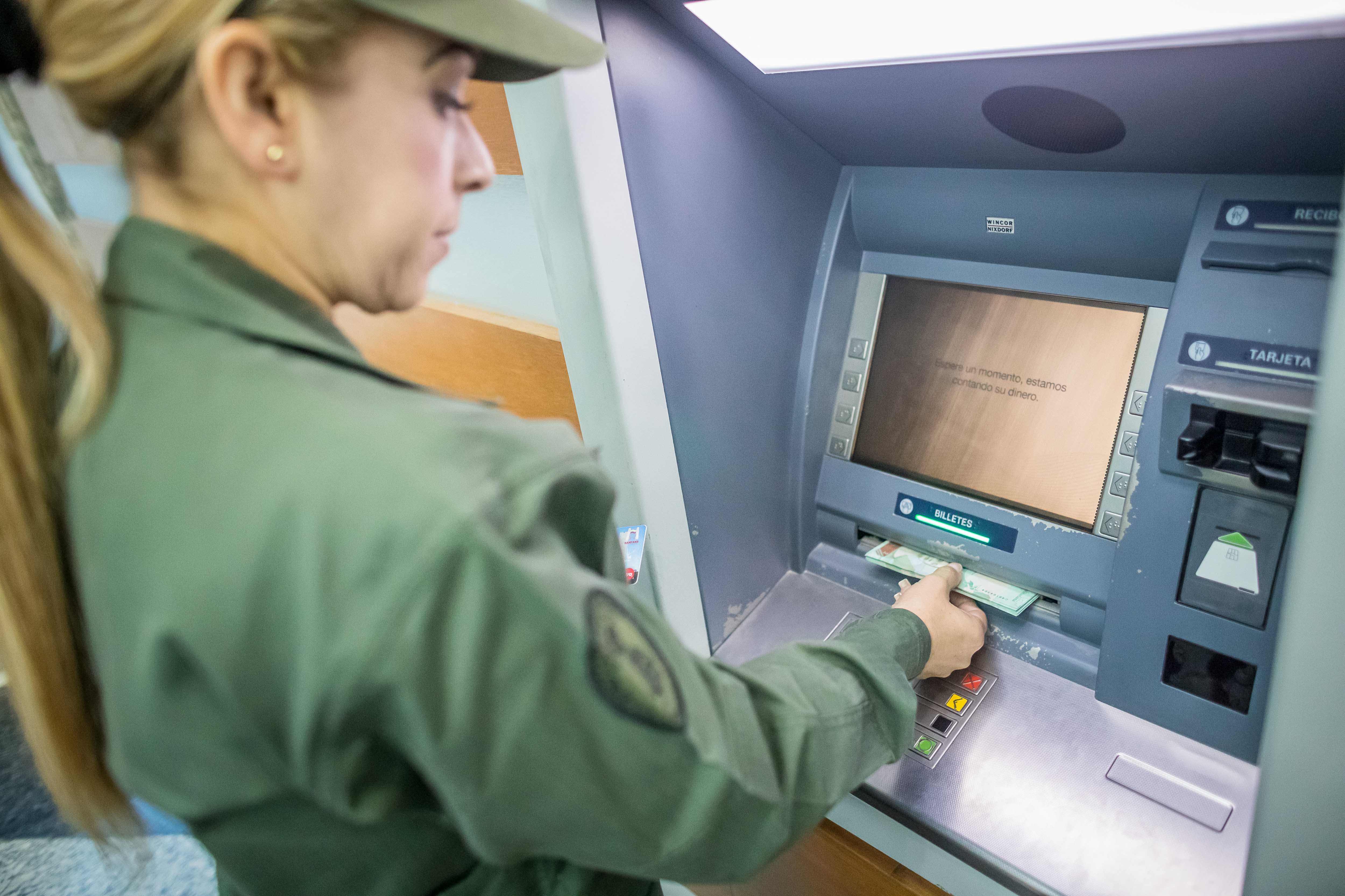 A Venezuelan soldier withdraws the country's new currency - the Bolivar Soberano, which slashes five zeros from the old prices - from an ATM in Caracas on Aug. 20, 2018. EFE-EPA/MIGUEL GUTIERREZ
