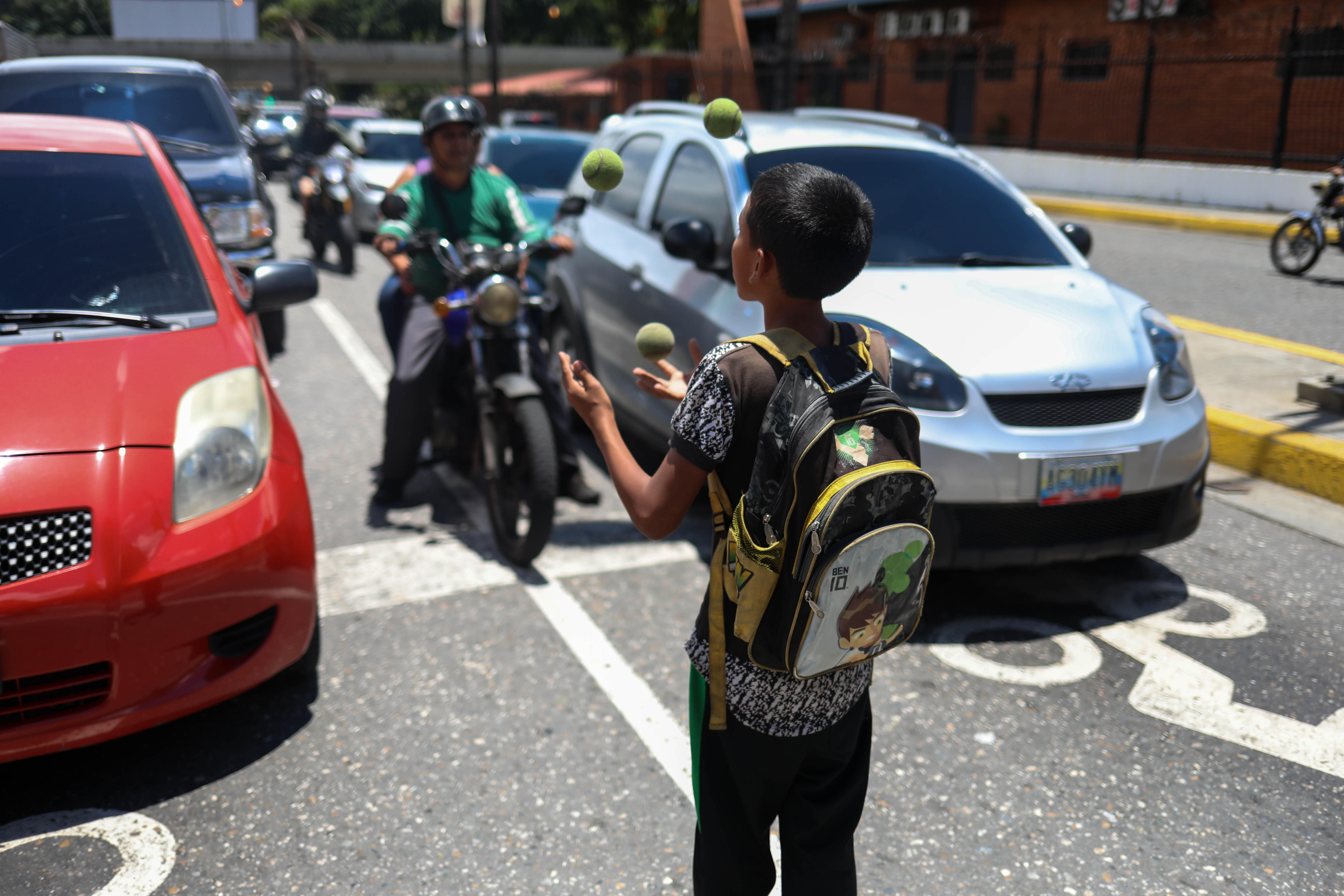 A boy left all on his own juggles for money or food on Aug. 24, 2018, in Caracas, where the terrible economic crisis Venezuela is going through has caused thousands of children to be left behind by their parents who have left the country to find somewhere they can make a decent living. EFE-EPA/Cristian Hernandez
