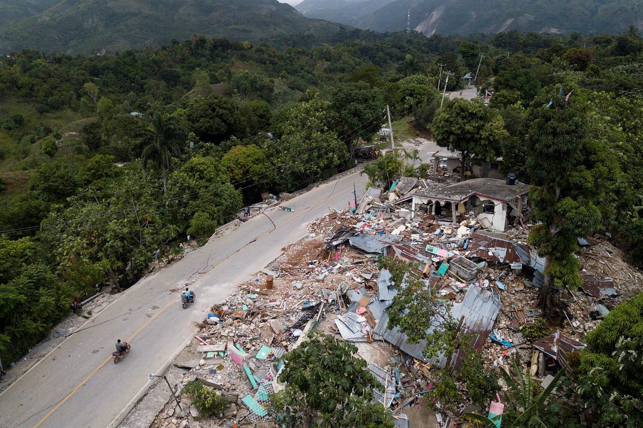 Homes lay in ruins along an earthquake-damaged road in Rampe, Haiti, Wednesday, Aug. 18, 2021, four days after 7.2-magnitude earthquake hit the southwestern part of the country. Photo Credit: Matias Delacroix, AP.