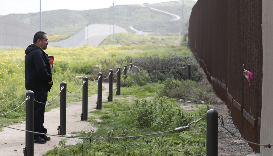 A man on the United States talks to a relative on the Mexican side through the 'Friendship Fence' between the United States and Mexico in the Border Field State Park in San Diego, California, USA, 26 March 2017. The park is the most southwest point in the United States. EFE/JASON SZENES
