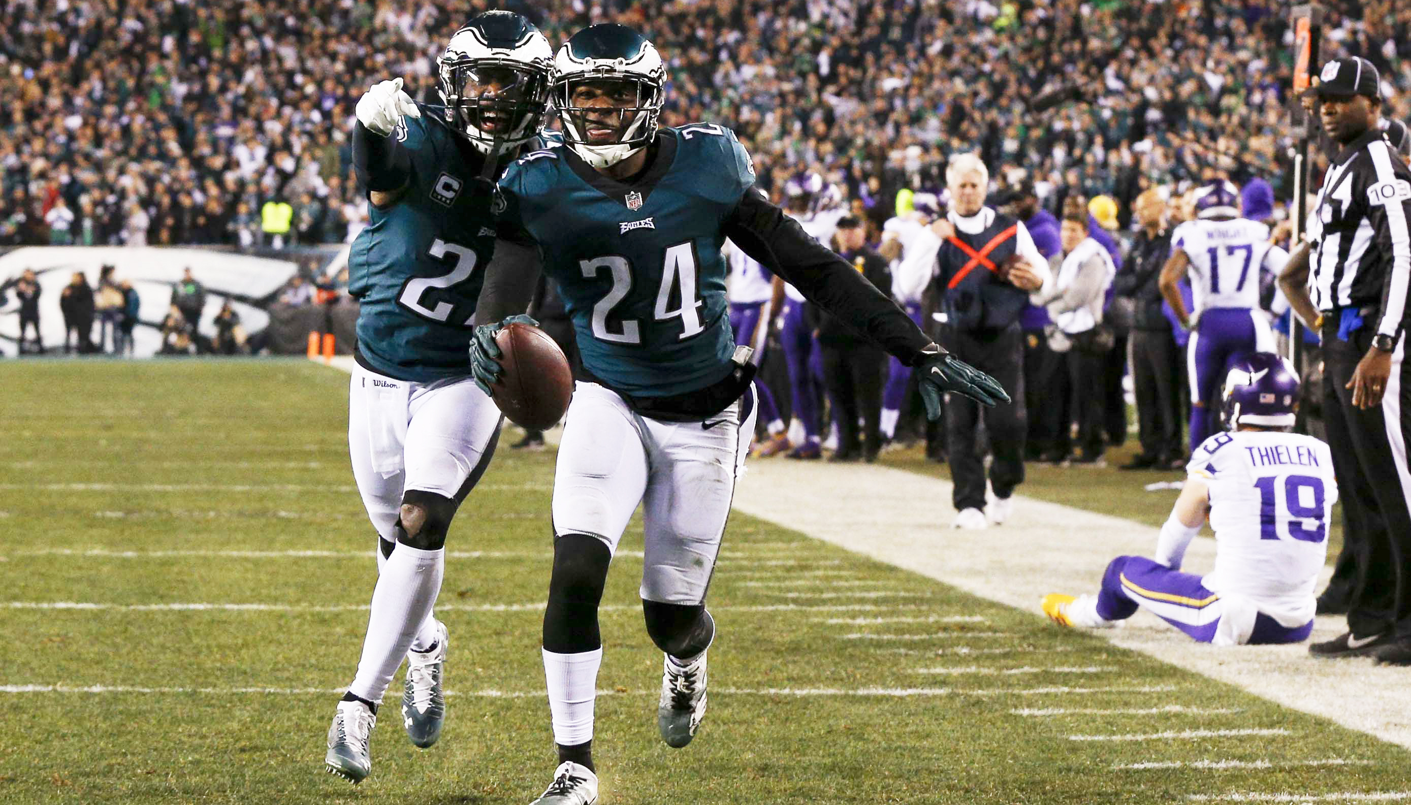 Malcolm Jenkins (I) y Corey Graham (C) de los Águilas celebran una intercepción mientras Adam Thieler (D) de los Vikingos se sienta en la tierra en la segunda mitad del juego de campeonato de la NFC entre los Vikingos de Minnesota y las Águlas de Filadelfia en Lincoln Financial Field. EFE
