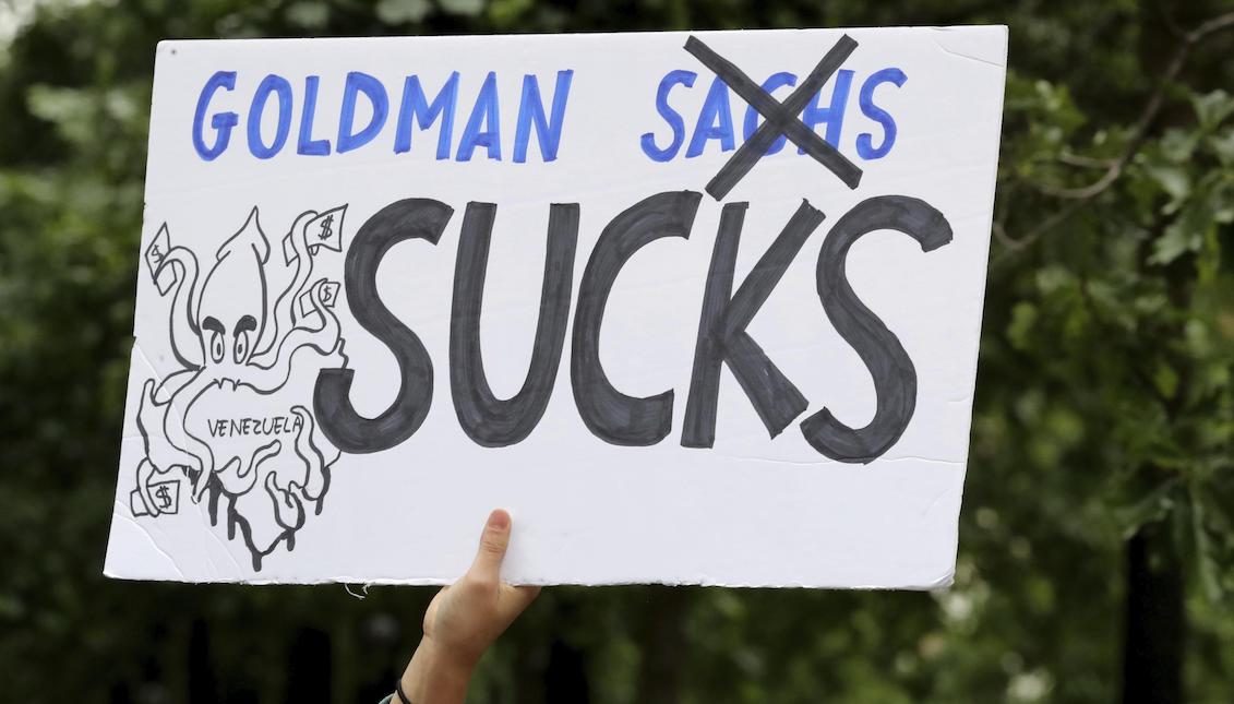 A person holds a poster that read “Goldman Sachs sucks”, during a demonstration against US investment firm Goldman Sachs in rejection of the alleged purchase of $ 2.8 billion in bonds from the Central Bank of Venezuela in New York, United States on May 30, 2017. EFE/Andrew Gombert