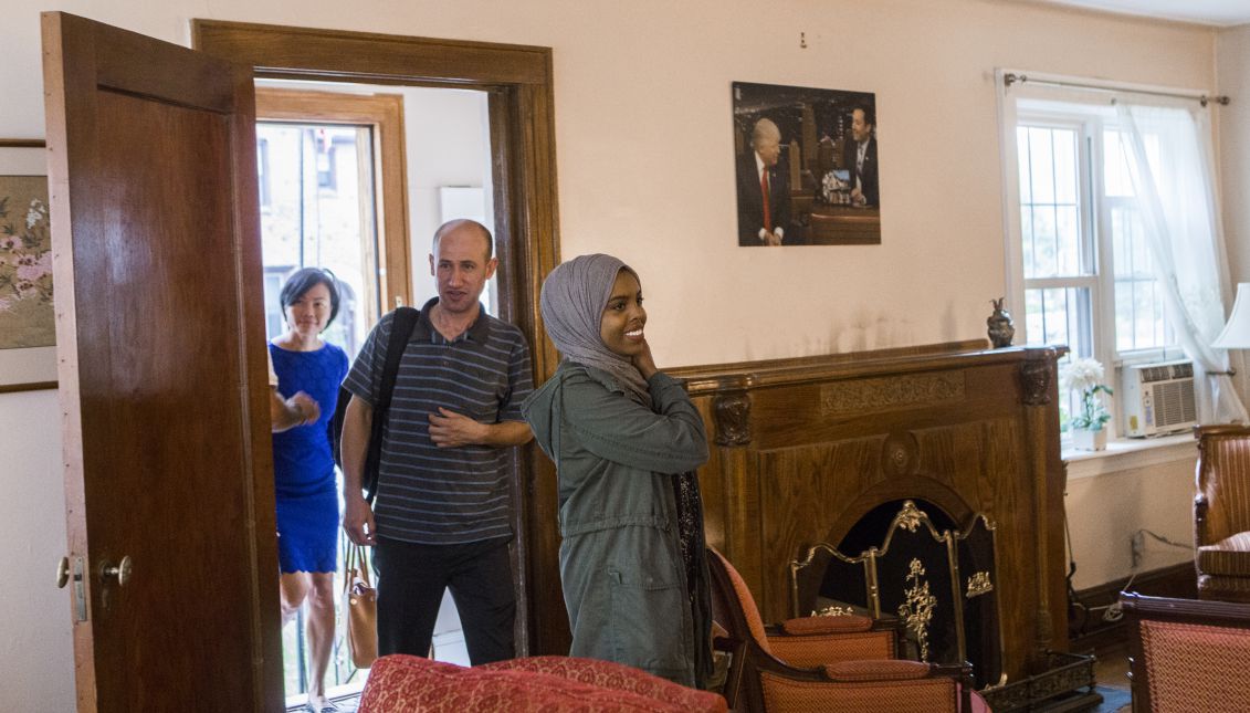 Abdi Iftin, of Somalia, Uyen Nguyen, of Vietnam, Eiman Ali, of Somalia born in Yemen, and Ghassan al-Chahada, of Syria pose for a photo at the living rood of President Donald Trump's boyhood home in Queens, New York. Oxfam rented the house that Trump’s father built on Airbnb and invited refugees to share their stories with journalists. (Oxfam)