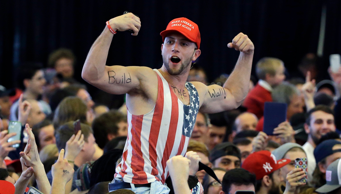 In this April 15, 2016, file photo, a Donald Trump supporter flexes his muscles with the words "Build The Wall" written on them as Trump speaks at a campaign rally in Plattsburgh, N.Y. Congressional Republicans and Donald Trump's transition team are exploring whether they can make good on Trump's promise of a wall on the U.S.-Mexico border without passing a new bill on the topic. AP