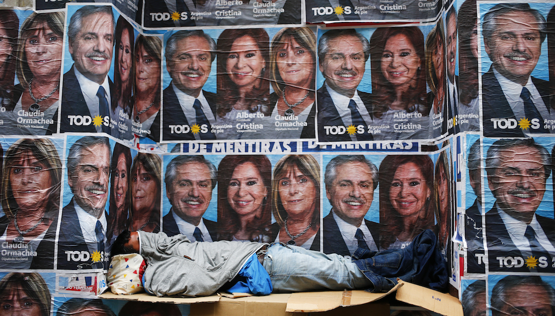 BUENOS AIRES, ARGENTINA - OCTOBER 28: A homeless sleeps next to posters advertising winning ticket of Frente de Todos represented by Alberto Fernandez and Cristina Fernandez on October 28, 2019, in Buenos Aires, Argentina. (Photo by Marcos Brindicci/Getty Images)