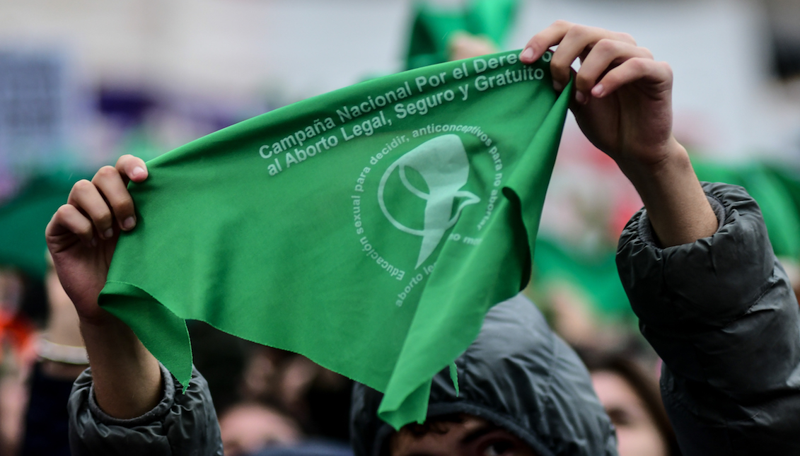 BUENOS AIRES, ARGENTINA - AUGUST 08: A Pro legal abortion activist holds up a green handkerchief in front of the National Congress Building while senators vote for the new abortion law on August 8, 2018, in Buenos Aires, Argentina. (Photo by Amilcar Orfali/Getty Images)