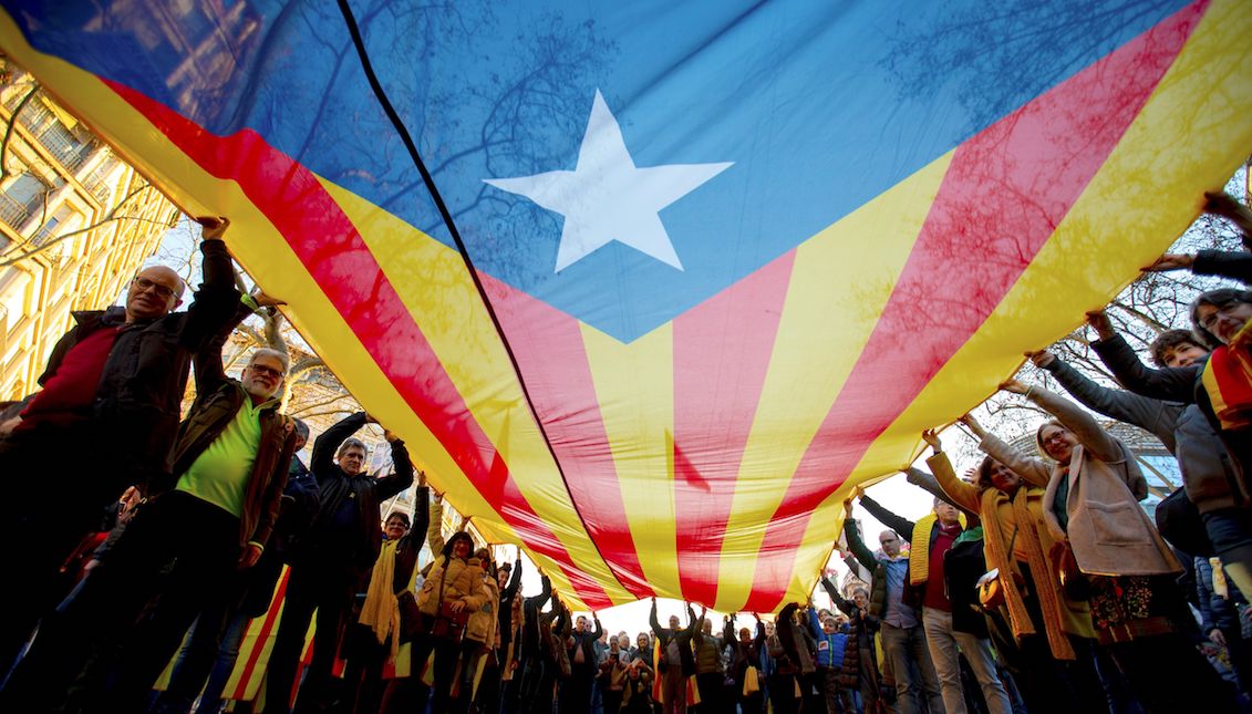 Varios manifestantes portan una gran estelada durante la movilización celebrada hoy en el centro de Barcelona para protestar contra el juicio del "procés", bajo el lema "la autodeterminación no es delito". EFE/ Enric Fontcuberta