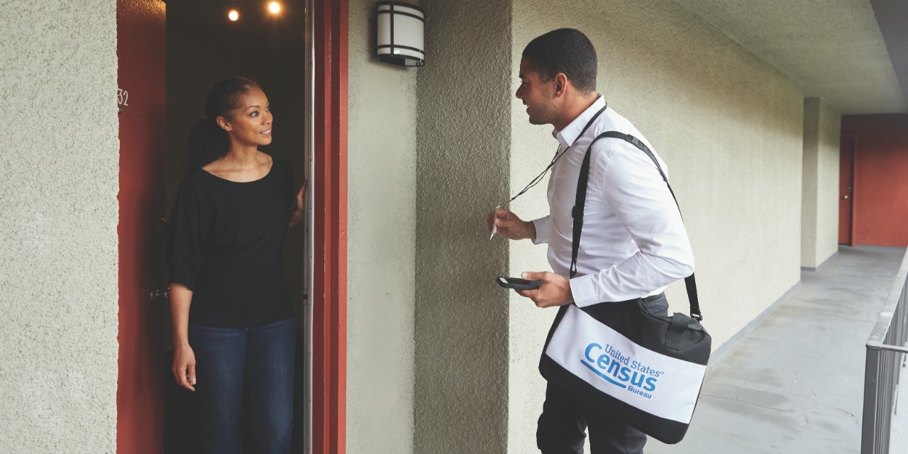 A census taker greets a resident at their home.