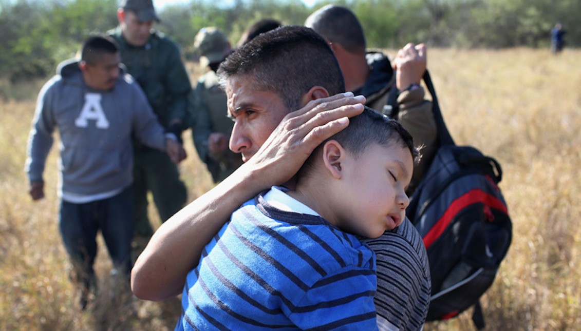 A father holds his 3-year-old son while he sleeps, having been arrested along with other undocumented immigrants by the Border Patrol on December 7, 2015 near Rio Grande City (Texas). Photo: John Moore / Getty Images.