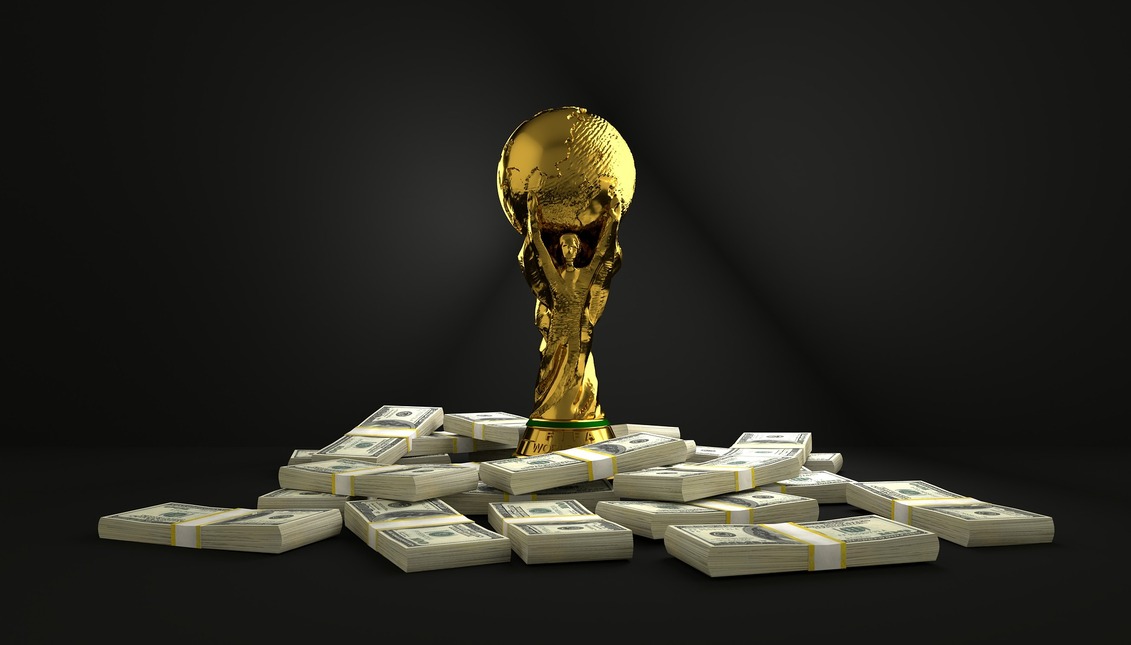 Image of the fifa world cup surrounded by wads of banknotes