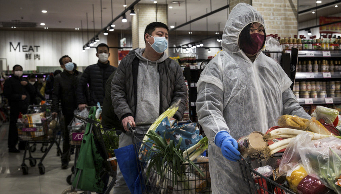 Los residentes usan máscaras de protección mientras hacen cola en el supermercado el 12 de febrero de 2020 en Wuhan, provincia de Hubei, China. Foto: Stringer/Getty Images