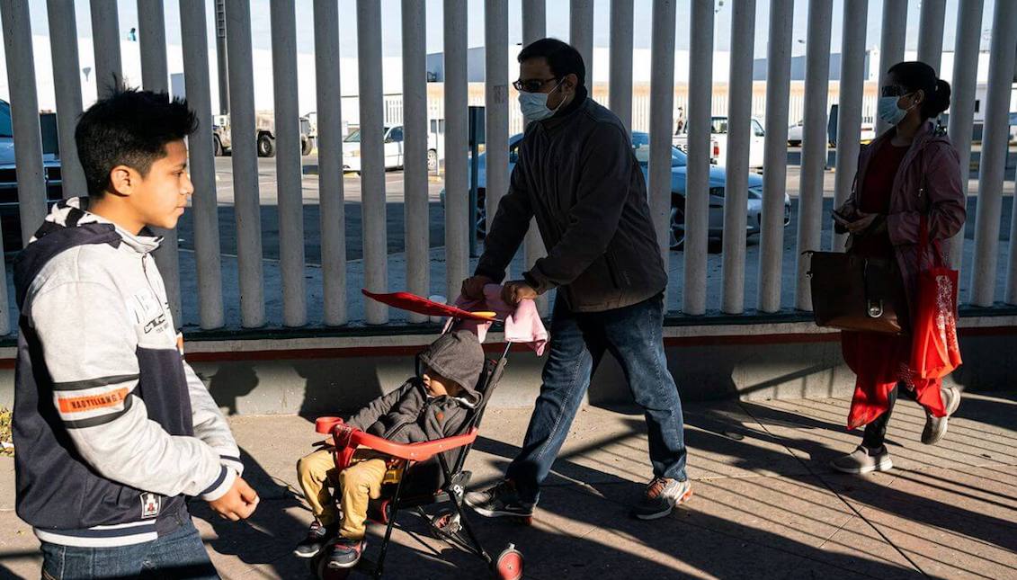 Asylum seekers wearing protective masks walk toward their appointment with US authorities the US-Mexico border in Tijuana, on February 29, 2020. Guillermo Arias/AFP via Getty Images