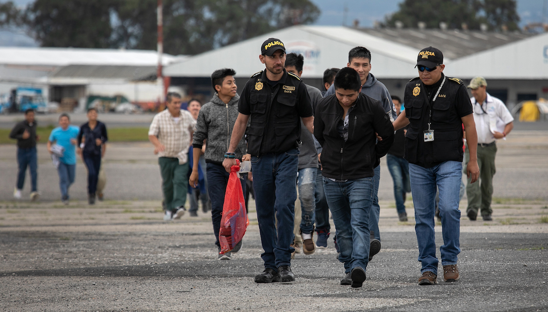 CIUDAD DE GUATEMALA, GUATEMALA - 30 DE MAYO: La policía guatemalteca escolta a un criminal acusado en la pista del aeropuerto después de que él y otros guatemaltecos fueron deportados de los Estados Unidos el 30 de mayo de 2019 en la ciudad de Guatemala. El Servicio de Inmigración y Control de Aduanas (ICE) de los EE.UU. despacha aviones para deportar a unas 2.000 personas por semana a Guatemala desde varias ciudades del país. (Foto por John Moore/Getty Images)