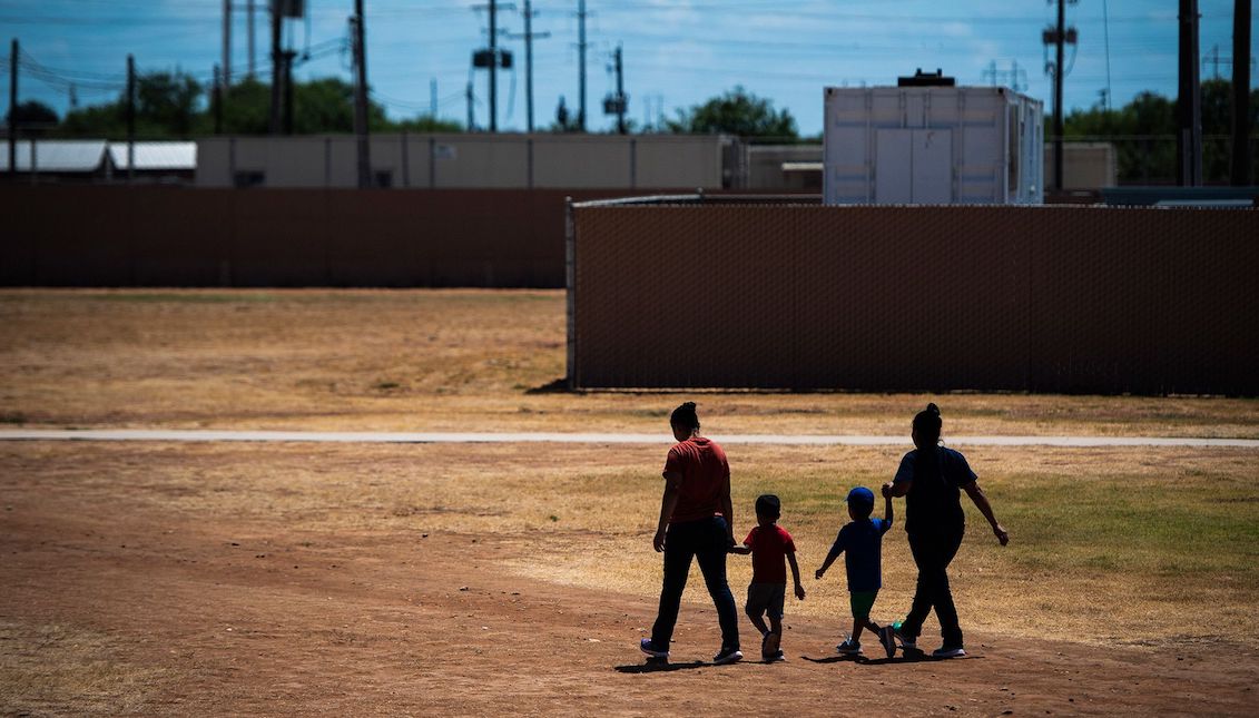 Immigrant women and children walk across a field as Immigration and Customs Enforcement and Enforcement and Removal Operations host a media tour at the South Texas Family Residential Center last summer in Dilley, Texas. Photo: Jabin Botsford/Getty Images.