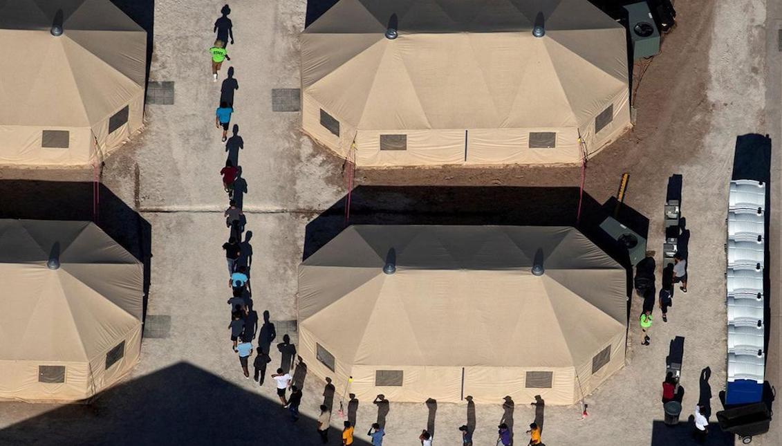 Immigrant children are led by staff in single file between tents at a detention facility next to the Mexican border in Tornillo, Texas, US, June 18, 2018. REUTERS