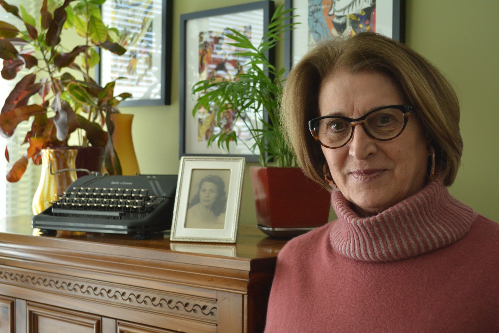 Dr. Concha Alborg poses with a photo of her mother, Concepción Carles, in the background. Photo: Courtesy of Dr. Concha Alborg