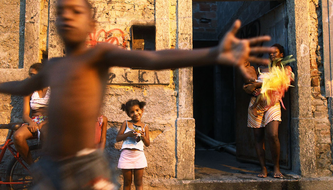 People gather as others march in the first street parade of the 2014 Carnival season through the historic Afro-Brazilian port district during the Circuito da Liga Portuaria parade on February 1, 2014 in Rio de Janeiro, Brazil.   Photo by Mario Tama/Getty Images