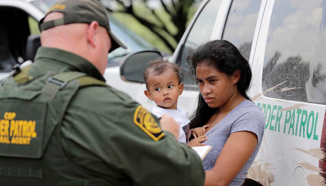 A Honduran woman, holding her 1-year-old child, surrenders to U.S. Border Patrol agents near McAllen, Tex. (David J. Phillip/AP)