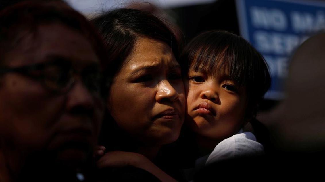 A girl hugs a woman while people hold signs to protest against the executive order of U.S. President Donald Trump to stop children crossing the southern border of the country and separate families. Los Angeles, California. (Reuters)