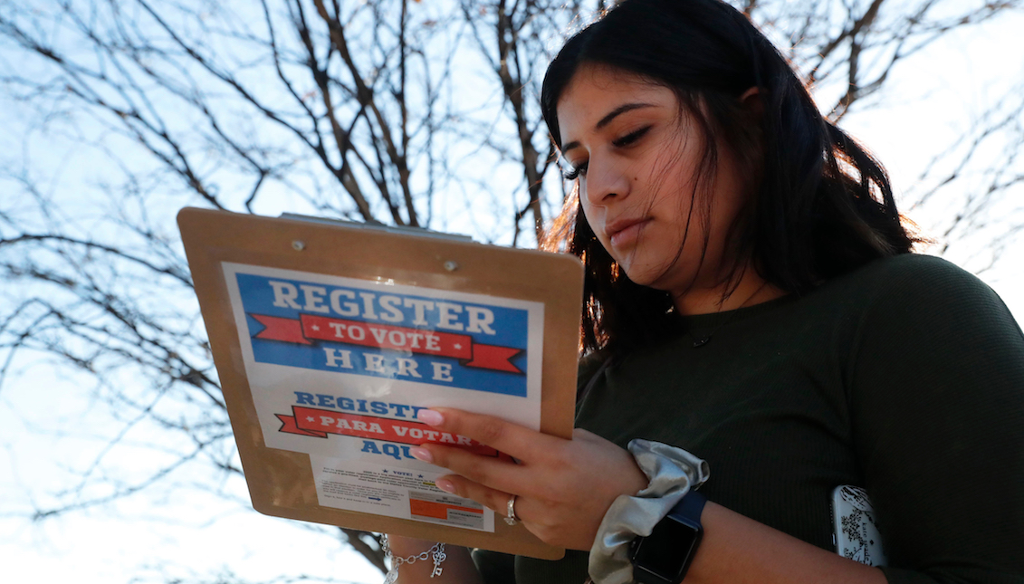 Karina Shumate, 21, a college student studying stenography, fills out a voter registration form in Richardson, Texas, Saturday, Jan. 18, 2020. (AP Photo/LM Otero)