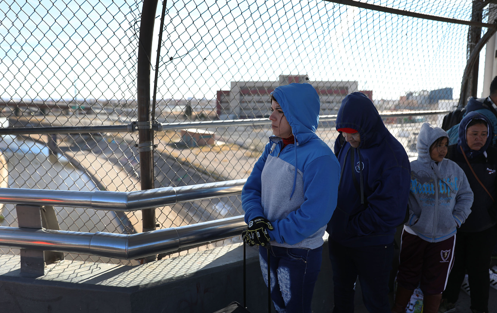 CIUDAD JUAREZ, MEXICO - JANUARY 13: A group of people, some journeying from Honduras, Mexico, Cuba, and Guatemala, wait at the Paso Del Norte Port of Entry bridge. (Photo by Joe Raedle/Getty Images) 