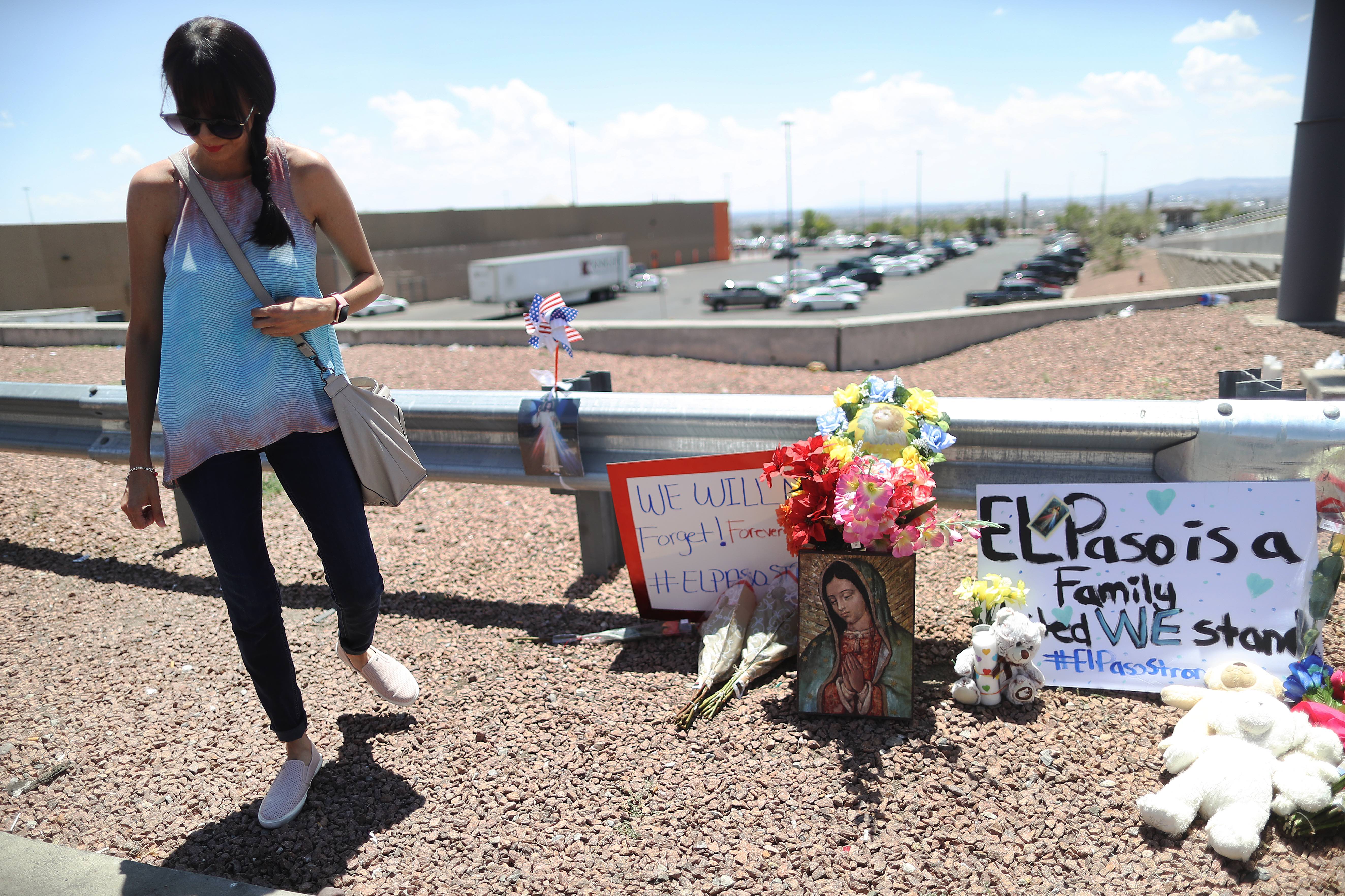 EL PASO, TEXAS - AUGUST 04: A woman walks away from a makeshift memorial outside Walmart, near the scene of a mass shooting which left at least 20 people dead, on August 4, 2019 in El Paso, Texas. A 21-year-old male suspect, identified as Patrick Crusius from a Dallas suburb, surrendered to police at the scene. At least 26 people were wounded in the shooting. (Photo by Mario Tama/Getty Images)