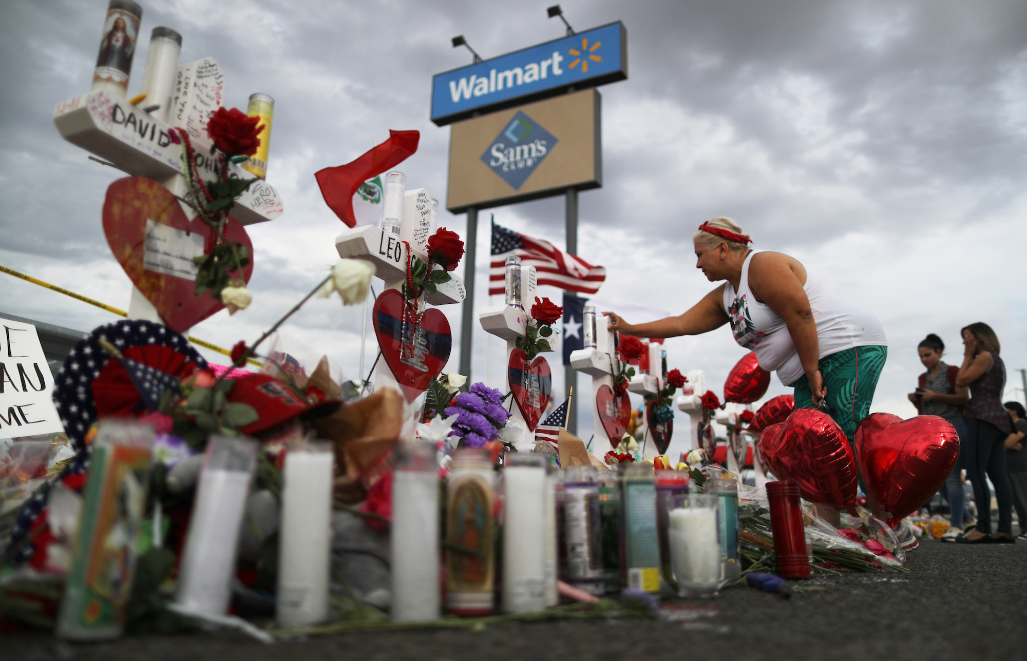 A woman touches a cross at a makeshift memorial for victims outside Walmart, near the scene of a mass shooting which left at least 22 people dead, on August 6, 2019 in El Paso, Texas. A 21-year-old white male suspect remains in custody in El Paso, which sits along the U.S.-Mexico border. President Donald Trump plans to visit the city August 7. (Photo by Mario Tama/Getty Images)
