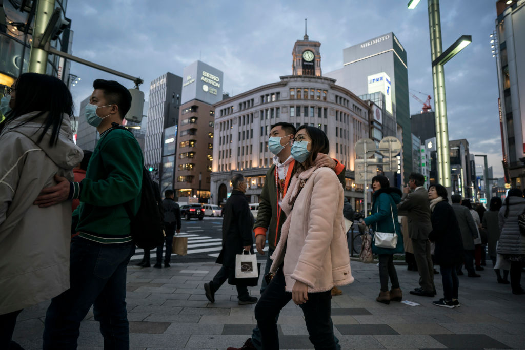 Chinese tourists wearing masks walk through the Ginza shopping district on January 24, 2020 in Tokyo, Japan. (Photo by Tomohiro Ohsumi/Getty Images)