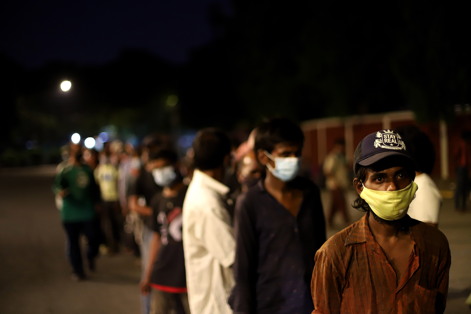 Daily wage laborers and homeless people wait to receive free food during a lockdown to limit the spread of the coronavirus disease (COVID-19), in New Delhi, India on May 07, 2021. Photo: Amarjeet Kumar Singh/Anadolu Agency via Getty Images
