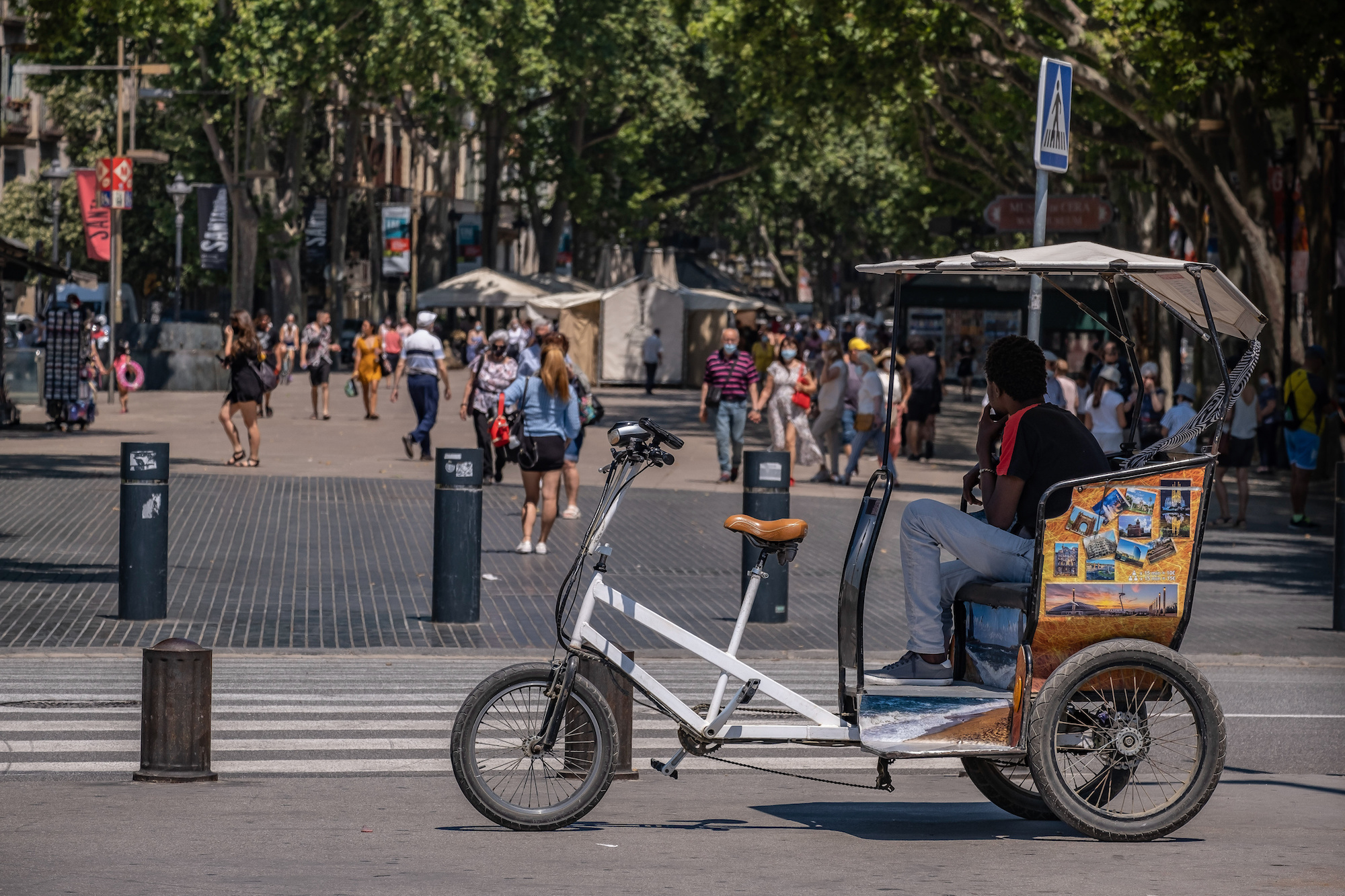 A pedicab waits for customers on Las Ramblas. With 50% of the citizens of Catalonia vaccinated with the first dose, tourism begins to be seen in the streets of Barcelona, especially in the historic center of the city. Photo: Paco Freire/SOPA Images/LightRocket via Getty Images 