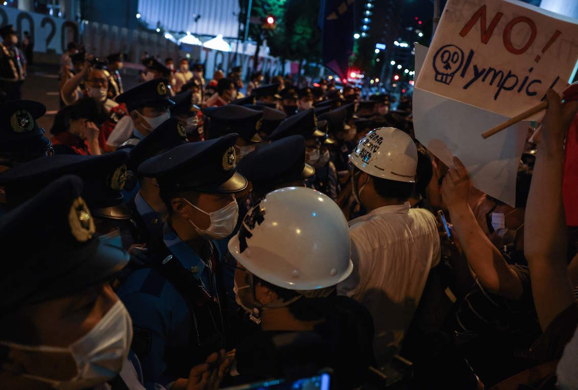 Police officers block protestors protesting against the Tokyo 2020 Olympic Games outside the Olympic Stadium during the opening ceremony of the Tokyo 2020 Olympic Games, in Tokyo, on July 23, 2021. Photo: Yuki Iwamura/AFP via Getty Images